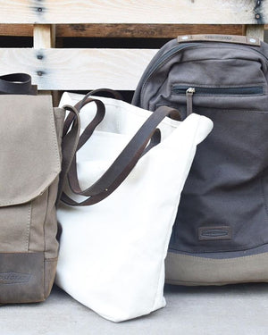 a saddle bag, canvas tote, and backpack