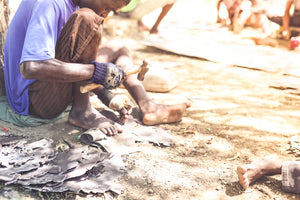 Haitian boy working on metal artwork.